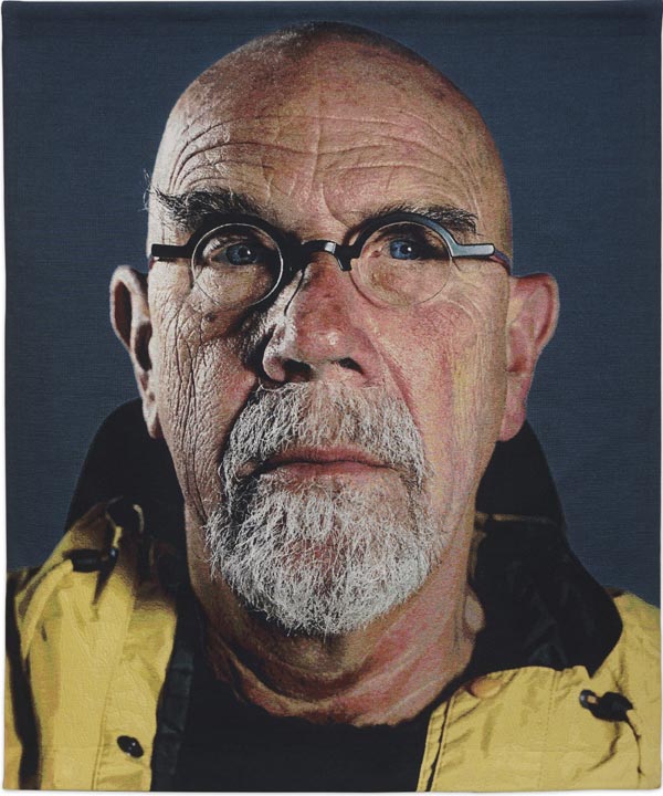 Chuck Close,  Self-Portrait (Yellow Raincoat), 2013, Jacquard tapestry, 93 x 76 in., Private Collection, © Chuck Close in association with Magnolia Editions, Photograph Courtesy Artist and Pace Gallery